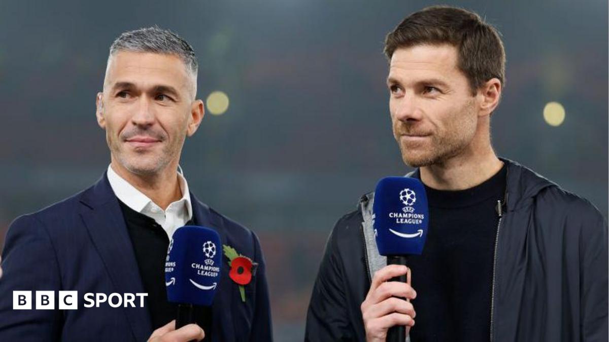 Luis Garcia and Xabi Alonso on a TV broadcast together holding Champions League-branded microphones